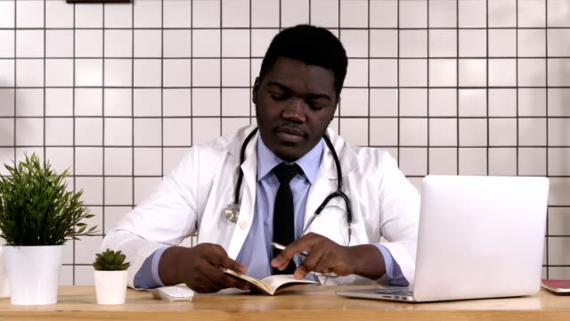 Africano-americano-médico-toma-notas