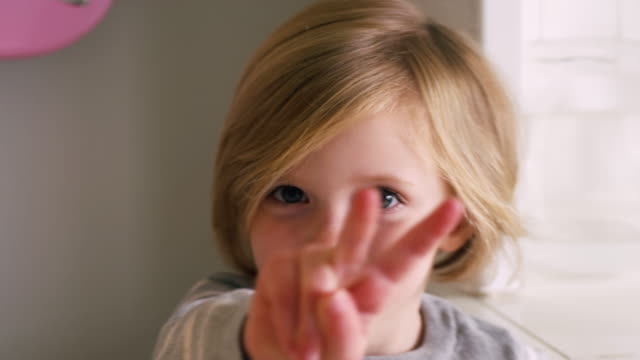 Kleines-Mädchen-posiert-und-damit-ein-Zeichen-des-Friedens-für-die-Kamera