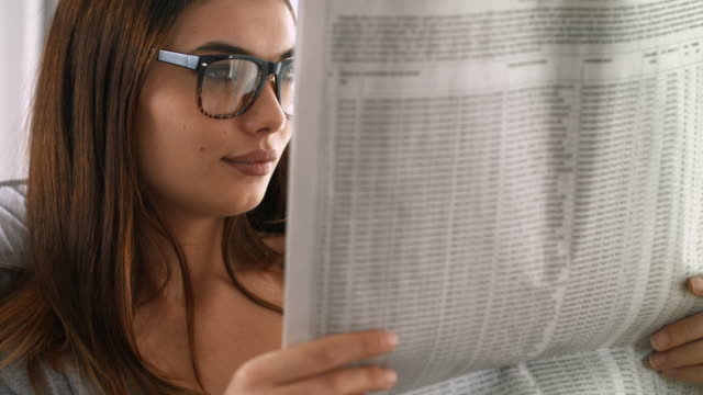 Mujer-joven-leyendo-periódico