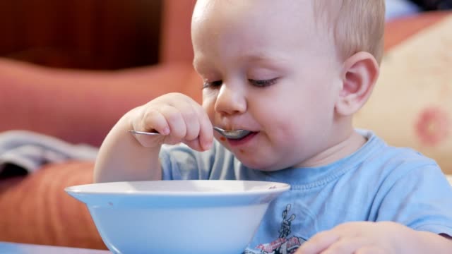 Eine-attraktive-junge-2-Jahre-alt-ist,-rote-Suppe-selbst-essen.-Löffel-und-Händen-fließt-Flüssigkeit.-Das-Konzept-einer-gesunden-Ernährung-von-Kindern