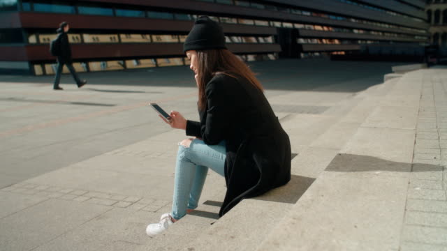 Portrait-of-young-African-American-woman-using-phone,-outdoors.