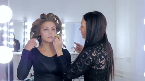 Makeup-artist-applying-liquid-tonal-foundation-on-woman's-face