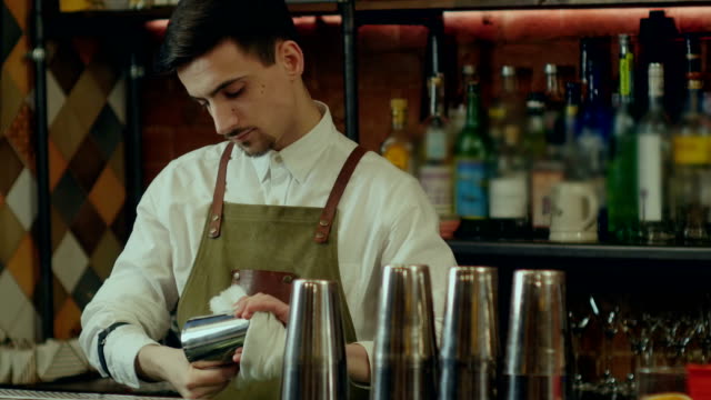 Barman-rub-metal-shakes-with-napkin-at-work-place