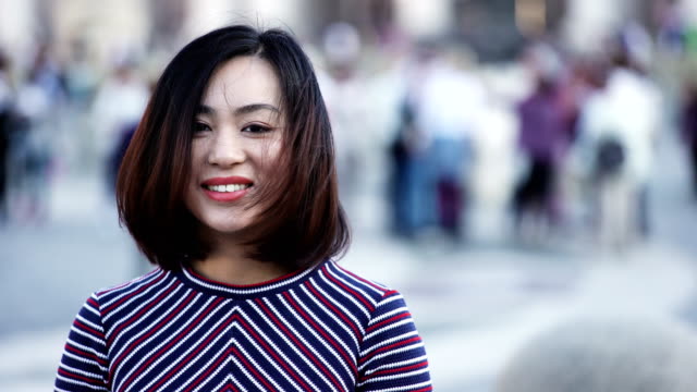 Portrait-of-playful-asian-woman-having-fun-outdoor-on-city-square