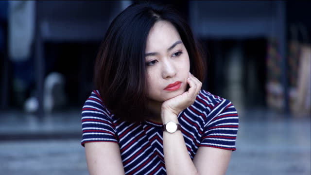 Mujer-asiática-solitaria-pensativa-sentado-en-la-ciudad:-Closeup-Retrato-mujer-triste