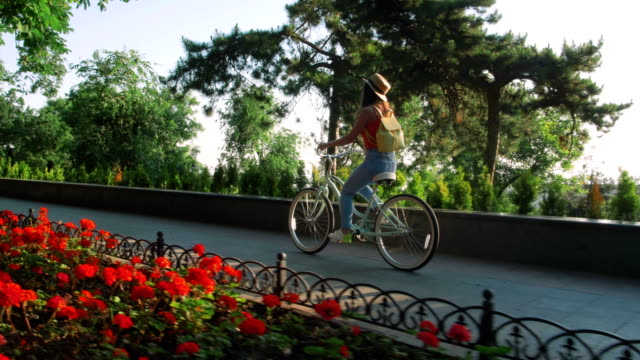 junge-schöne-Frau-mit-dem-Fahrrad-in-einem-park