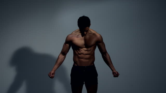 Fitness-Modell-zeigt-seine-Physis-durch-seine-Arme-ausstrecken