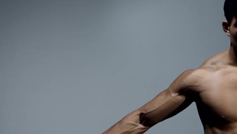 Fitness-masculino-modelo-flexiona-bíceps-y-extensiones-de-brazo