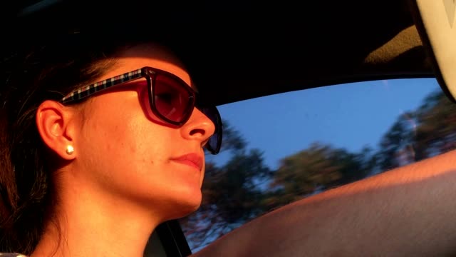 Drive.-Close-up-of-young-woman-driving-during-sunset-time