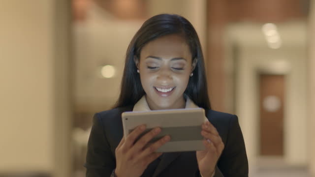 Joven-atractivo-las-mujeres-negras-con-Tablet-PC-buscando-en-la-Web-en-línea.-African-American-mujer-en-traje-de-conexión-con-las-redes-sociales.-Fondo-de-estilo-de-vida-urbano