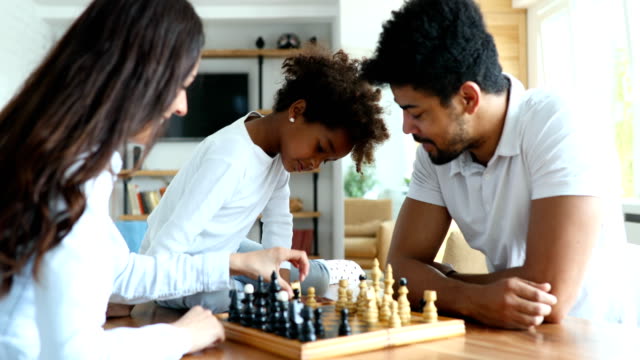 Glückliche-Familie-zusammen-Schach-zu-spielen,-die-zu-Hause
