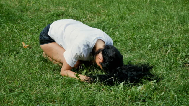 Junge-Frau-macht-Yoga-ausüben,-auf-dem-Rasen