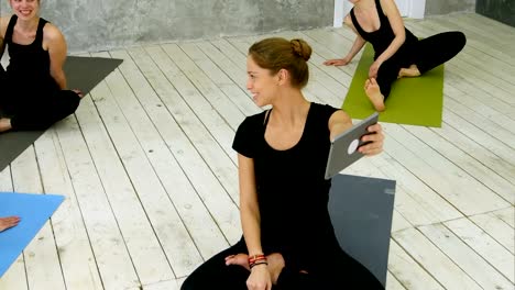 Retrato-de-sonriente-fit-mujer-uso-de-tableta-digital,-tener-chat-de-vídeo-mientras-está-sentado-en-la-estera-de-yoga-después-de-entrenamiento-de-fitness