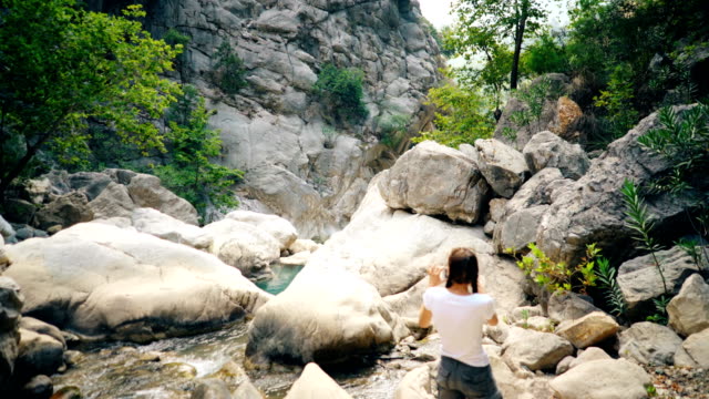 Junge-Touristen-Frau-nehmen-Foto-von-schönen-Canyon-auf-ihrem-Smartphone-Kamera-während-der-Fahrt