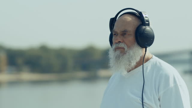 Pleasant-old-man-has-a-relax-listening-music-with-headphones