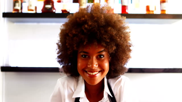Portrait-of-confident-waitress-standing-at-counter