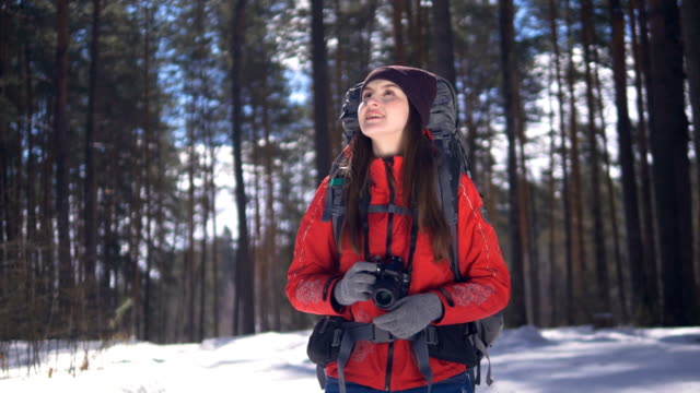 Glückliche-junge-Frau-in-einen-Winterwald-fotografieren-mit-Fotokamera.