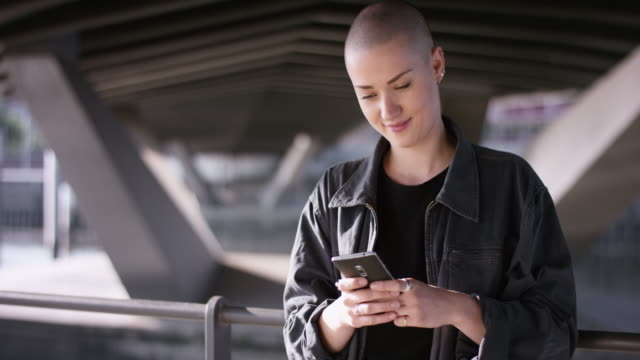 Moderne-Mädchen-mit-Buzz-Schnitt-eine-Nachricht-zu-schreiben,-auf-smartphone