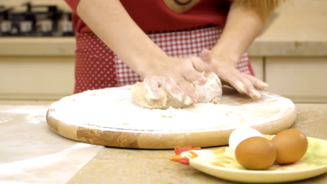 Female-kneads-dough-at-the-board