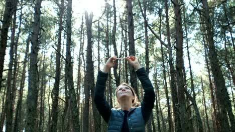 Mujer-toma-una-foto-de-árboles-en-bosque-en-el-teléfono