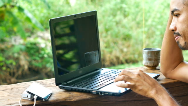 Empresario-asiático-utilizando-la-computadora-portátil-en-su-casa