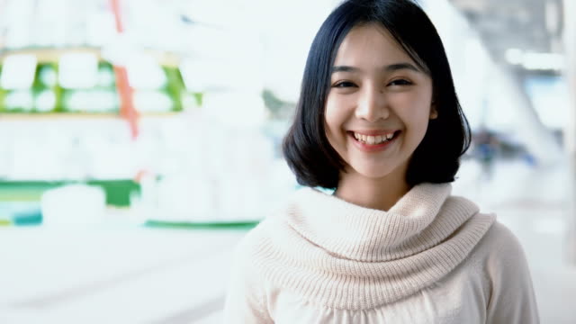 Hübsche-Asiatin-Blick-in-die-Kamera-und-lächelnd