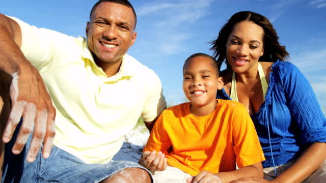 Portrait-of-ethnic-parents-and-son-on-beach