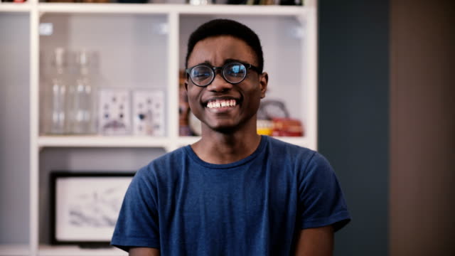 Happy-African-American-businessman-looks-at-camera.-Handsome-black-young-guy-in-glasses-smiling-joyfully.-Student.-4K