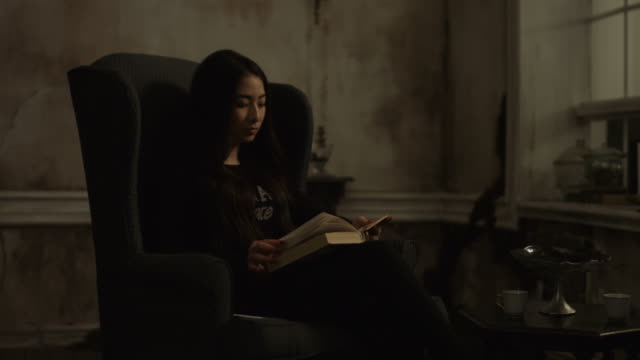 Schöne-junge-asiatische-Frau-Lesebuch-in-der-Nacht