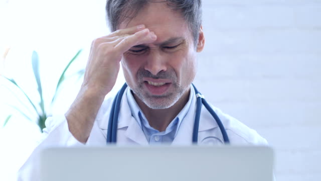 Headache,-Tense-Doctor-working-in-Clinic,-Close-Up