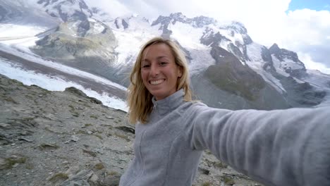 Female-hiker-taking-selfies-in-the-heart-of-the-Swiss-Alps-in-Zermatt,-Switzerland.