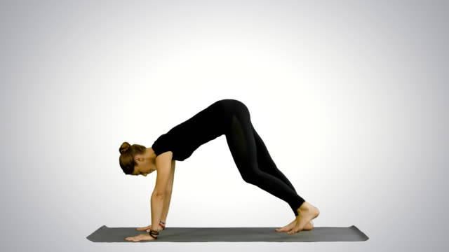 Mujer-haciendo-hacia-arriba-perro-Yoga-posición,-parte-del-saludo-al-sol-sobre-fondo-blanco