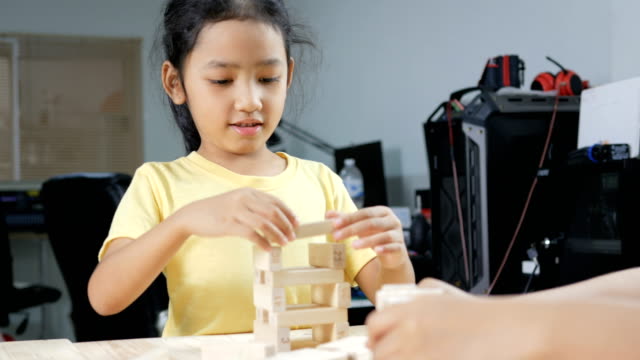 Cerrar-tiro-niña-asiática-jugando-juguetes-de-madera-ladrillo