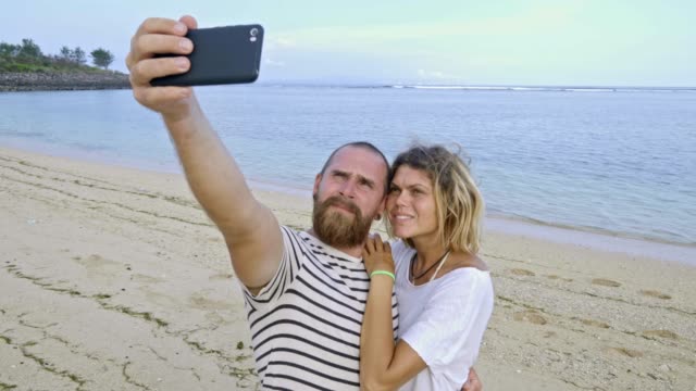 Couple-Taking-Picture-with-Smartphone-on-Beach