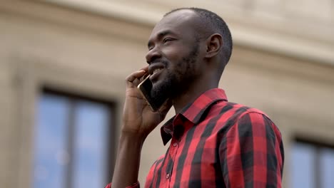 Lächelnde-schwarze-Afrikaner-sprechen-per-Telefon-in-der-Straße