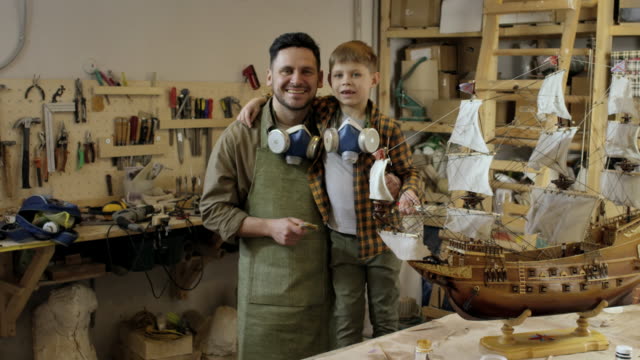Proud-Father-and-Son-Posing-in-Carpentry-Workshop