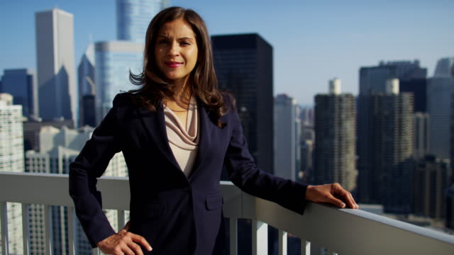 Portrait-of-Hispanic-businesswoman-on-rooftop-overlooking-Chicago