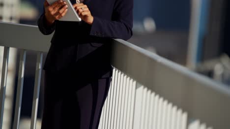Portrait-of-Hispanic-businesswoman-using-tablet-on-rooftop