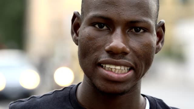 Afrikanische-amerikanische-jungen-Mann-lächelnd-in-die-Kamera-auf-der-Straße