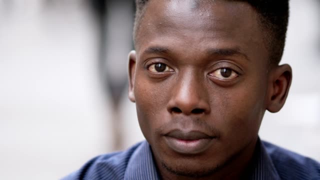 Porträt-von-Relaxed-attraktiver-junger-schwarzer-afrikanischer-Mann-starrte-auf-Kamera-Outdoor-Nahaufnahme