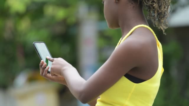 Junge-afrikanische-Frau-mit-Telefon-im-freien