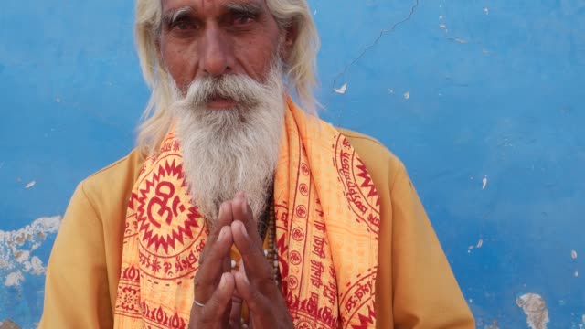 Sadhu-hindú,-hombre-santo,-sonriendo-y-las-manos-en-mudra-de-oración-namaste