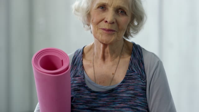 Mujer-Senior-con-Yoga-Mat-posando