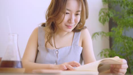 Estudiante-chino-joven-con-libros-en-la-biblioteca