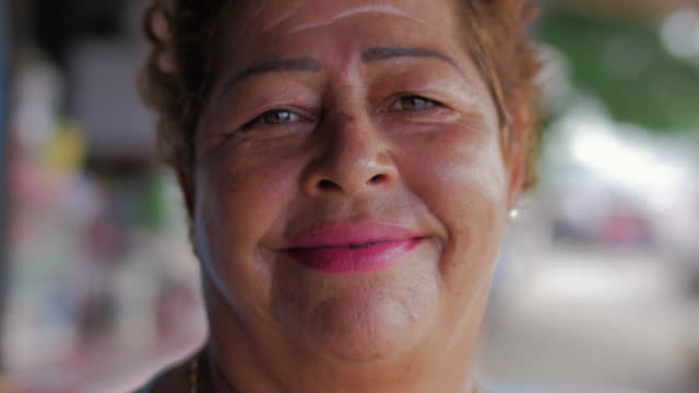 Close-up-Portrait-einer-älteren-hispanische-Frau-mit-einem-silbernen-Zahn-lächelnd-in-die-Kamera