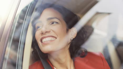 Schöne-glückliche-Frau-reitet-auf-dem-Beifahrersitz-eines-Autos,-schaut-verwundert-auf-große-Stadtansicht.-Kamera-Auto-außen-bewegen.