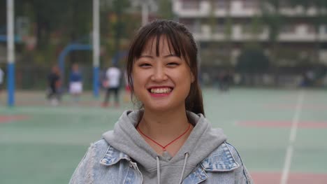 Porträt-der-jungen-Asiatin-Lächeln-in-die-Kamera-auf-dem-campus