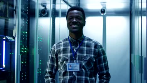 Hombre-negro-sonriente-en-la-sala-de-servidores