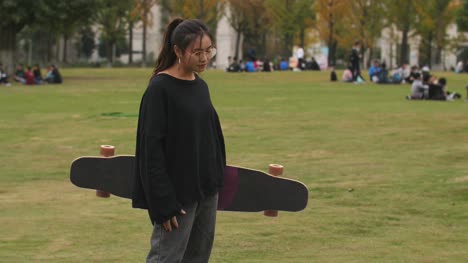 Asiatische-weibliche-College-Student-Portrait-mit-skateboard