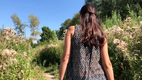 Joven-mujer-caminando-en-el-bosque